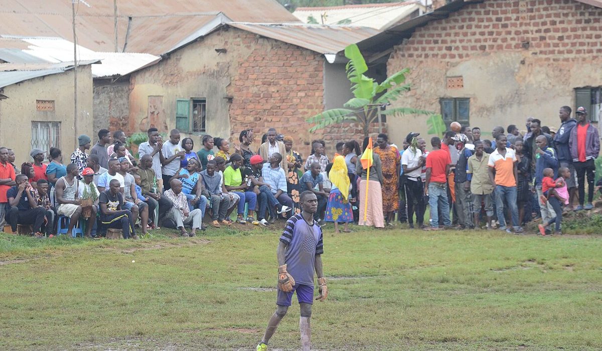Football supporters watching a match by the pitch