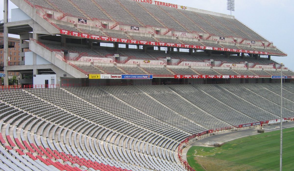 Stadium stand with red seats and the pitch below